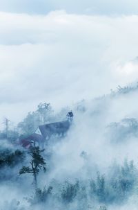 Scenic view of foggy weather against sky