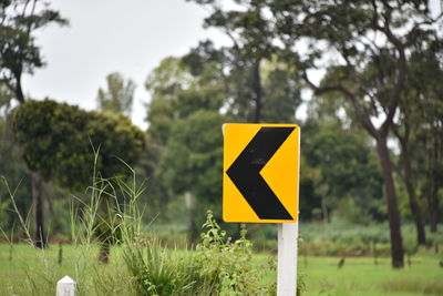 Close-up of road sign on field