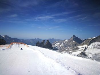 Scenic view of snowcapped mountains against blue sky