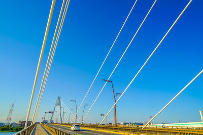 Low angle view of suspension bridge against blue sky