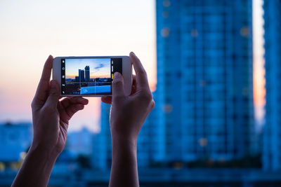 Close-up of woman photographing with mobile phone