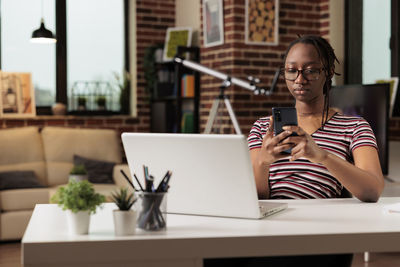 Young woman using laptop at table