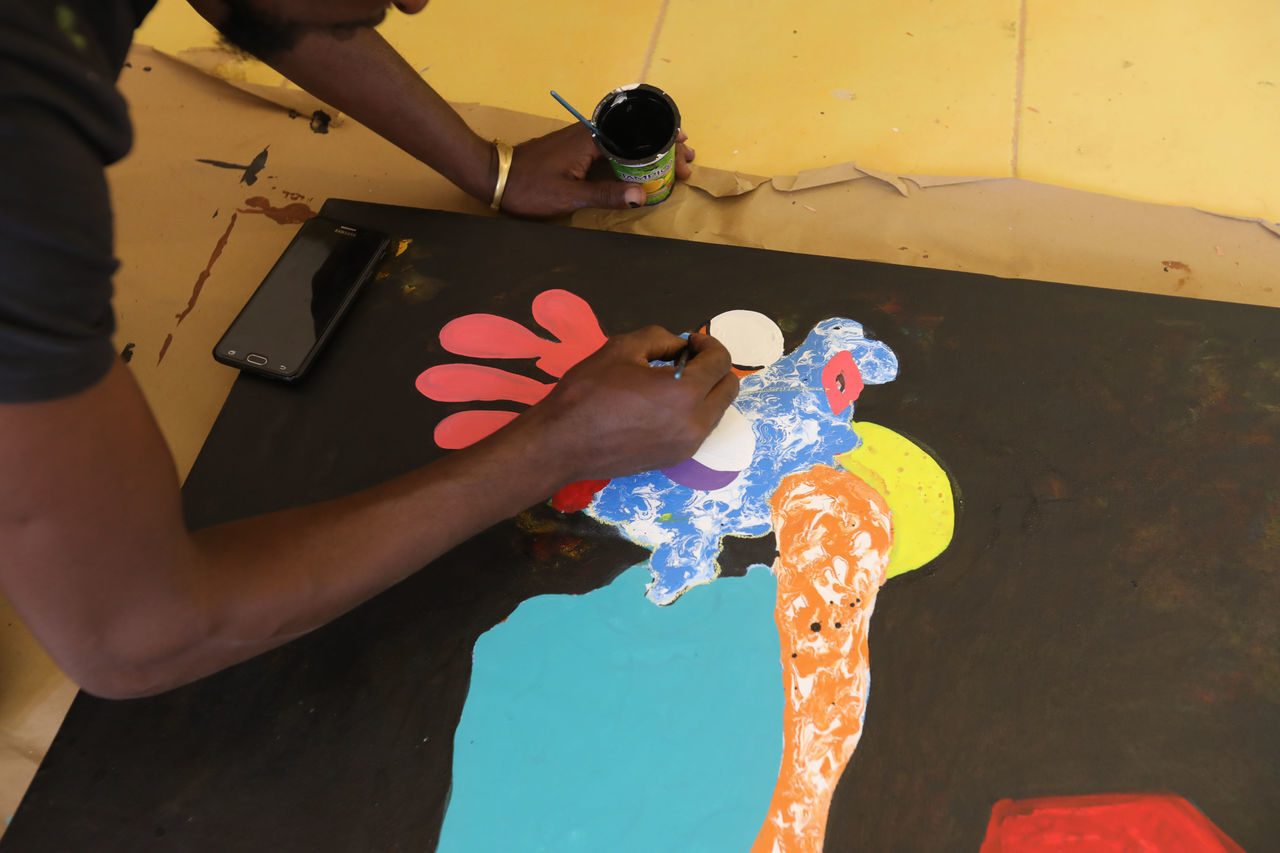 HIGH ANGLE VIEW OF MAN WITH HAND HOLDING PAINTING