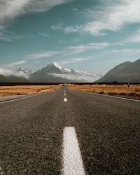 Road leading towards mountain against sky