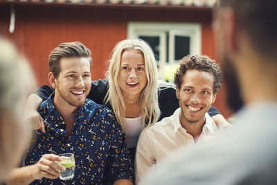 Smiling woman standing with friends at garden party