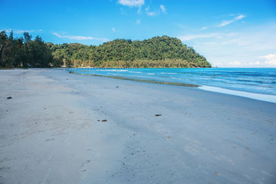 Scenic view of beach against blue sky