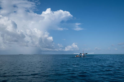 Sailboat sailing in sea against sky