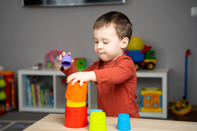 Portrait of cute baby boy playing with toys at home