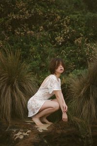 Side view of a girl sitting on plant