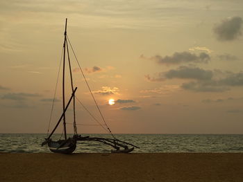 Sailboat on sea against sky during sunset