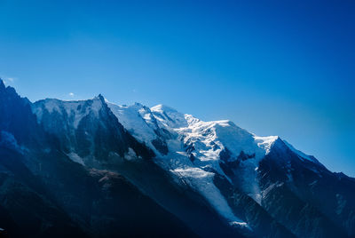 Scenic view of snowcapped mountains against clear blue sky