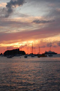 Sailboats sailing on sea against sky during sunset