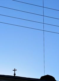 Low angle view of power lines against clear blue sky