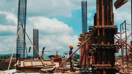 Manual worker standing at construction site against sky