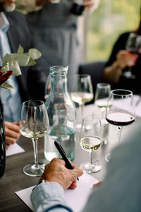 Cropped image of businessman writing on document at table in convention center