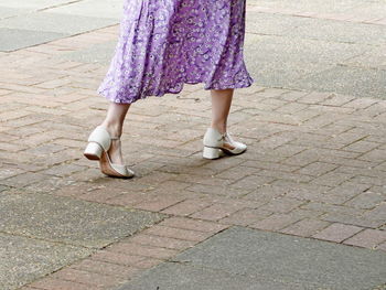 Low section of woman walking on footpath