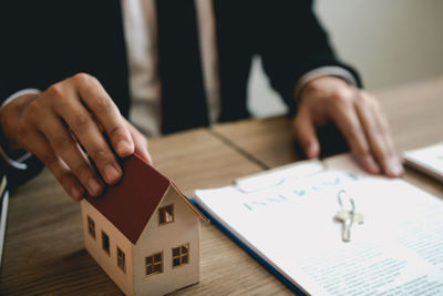 Midsection of person holding paper on table