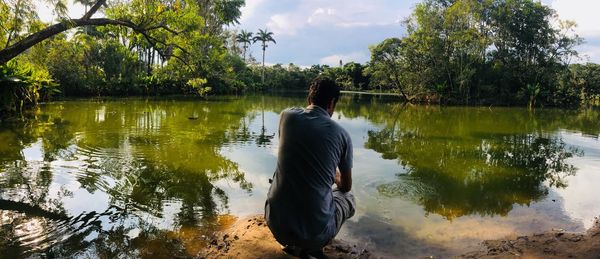 Rear view of man in lake against sky