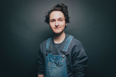 Portrait of young man standing against wall