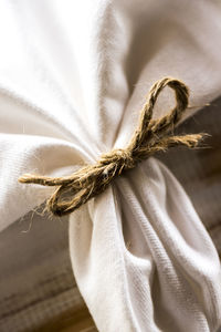 Close-up of rope tied to tied fabric on table
