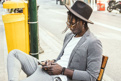 Young man sitting on street