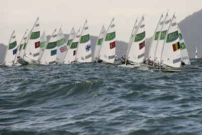 People sailing on sea against sky