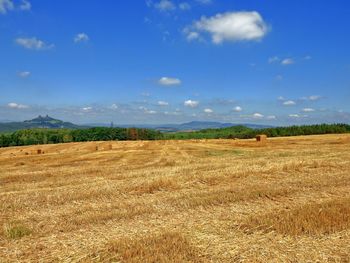 Scenic view of field against cloudy sky