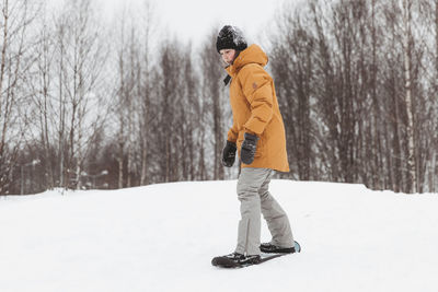 Cute teenage girl rides a snowskate in a winter park, healthy lifestyle