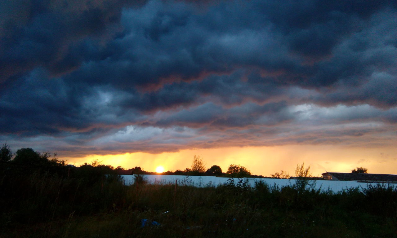 cloud - sky, sunset, sky, nature, dramatic sky, beauty in nature, scenics, atmospheric mood, tranquil scene, storm cloud, tranquility, no people, weather, dusk, grass, outdoors, landscape, silhouette, tree, lake, water, day