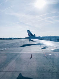 Airplane on runway against sky on sunny day