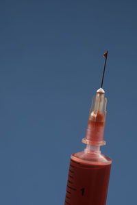 Injection syringe with needle detail on colored background with space for text