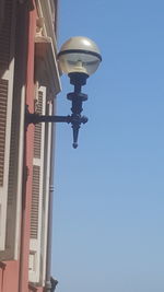 Low angle view of street light against building