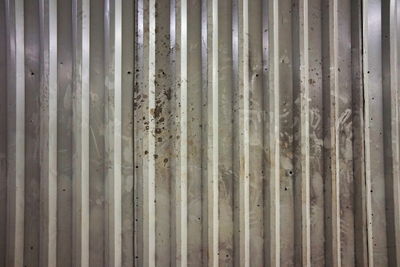 Full frame shot of metal fence against wall
