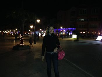 Man standing on road at night