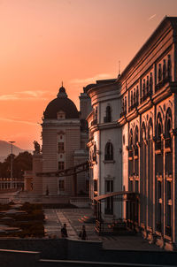 Buildings in city against sky during sunset