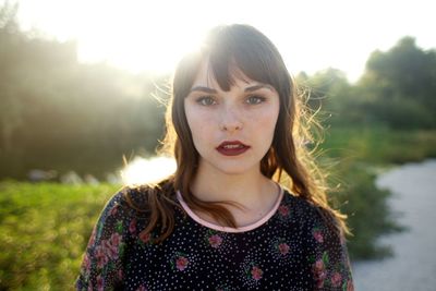 Portrait of woman standing by plants against sky