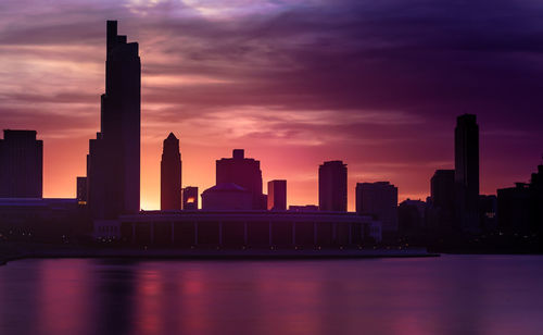 Modern buildings against sky during sunset