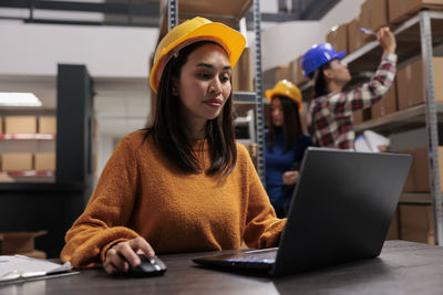 Portrait of young woman using laptop at cafe