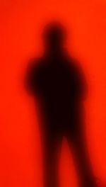 Rear view of silhouette person against red background