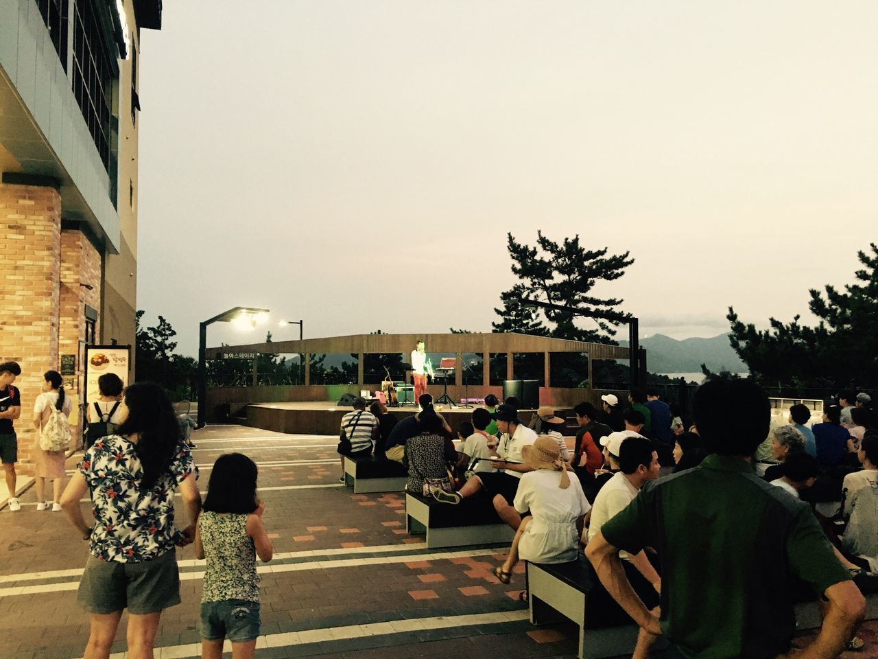 PEOPLE WALKING ON SIDEWALK AGAINST CLEAR SKY