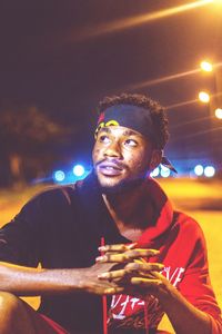 Portrait of young man looking away at night