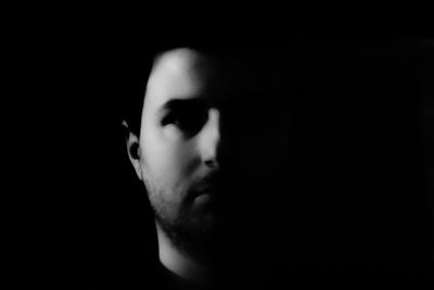 Close-up of man against black background