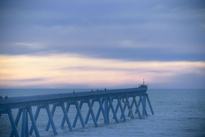 Large view of a wharf over the ocean against sunset sky