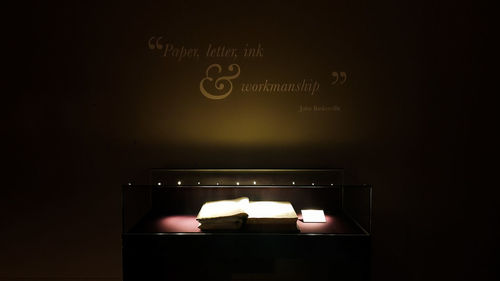 Close-up of illuminated text on wall in darkroom