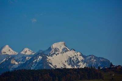 Scenic view of snowcapped mountains against clear blue sky