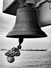 Close-up of ships bell against sky