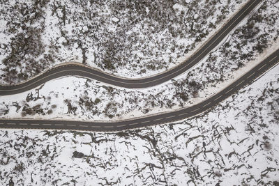 Road by trees against sky during winter