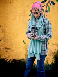 Beautiful asian female posing with a retro camera