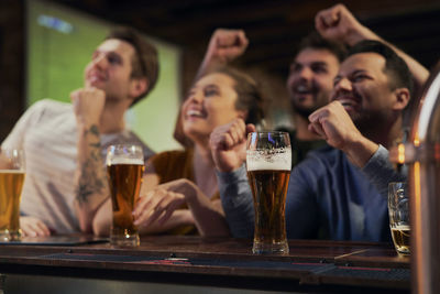 Happy friends watching soccer match at bar