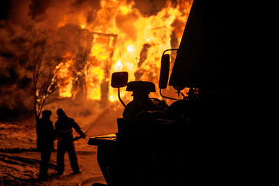 Firefighters spraying water on burning fire at night